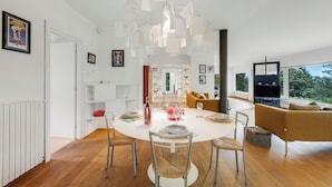 A modern dining area with a round table, chairs, and a unique ceiling light fixture. - Il Gioiellino Pool And Sauna (Gignese)