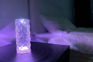 A room with a bed, a bedside table, and a decorative glass object on the table. - Pattaya Music Villa (Pattaya)
