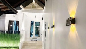 Una casa moderna con una scala che porta a una porta, pareti bianche e un ingresso luminoso.