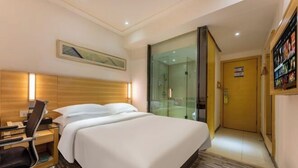 A hotel room with a bed, bedside table, chair, and a glass-enclosed shower area. - Bohan Hotel (Guangzhou Olympic Sports Center – Tangxia Metro Station Branch) (Guangzhou)
