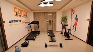 A home gym with a treadmill, bench, dumbbells, and a kettlebell. - Bohan Hotel (Guangzhou Olympic Sports Center – Tangxia Metro Station Branch) (Guangzhou)