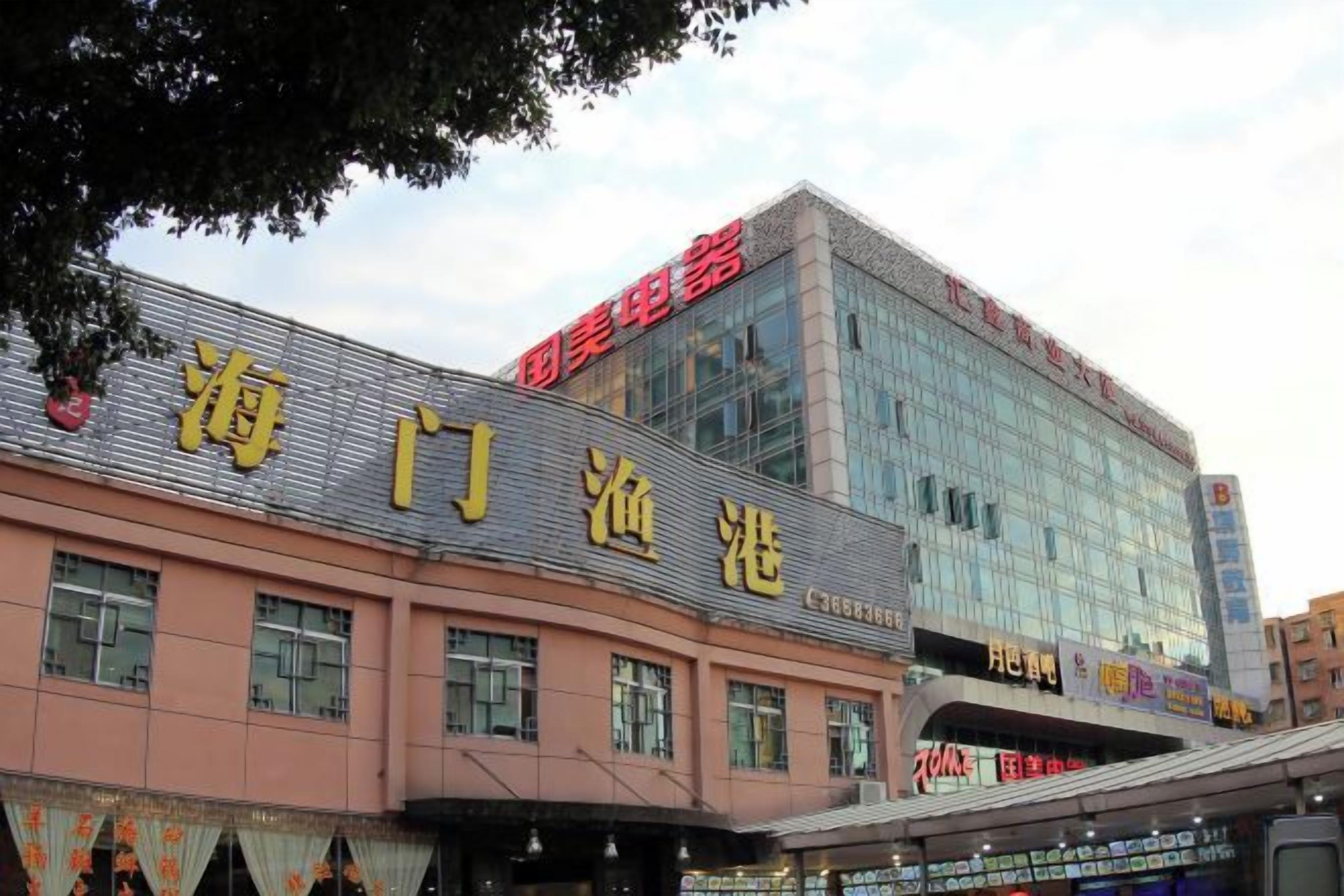 A building with a large sign reading '海门渔港' and another sign above it reading '红旗家电'.