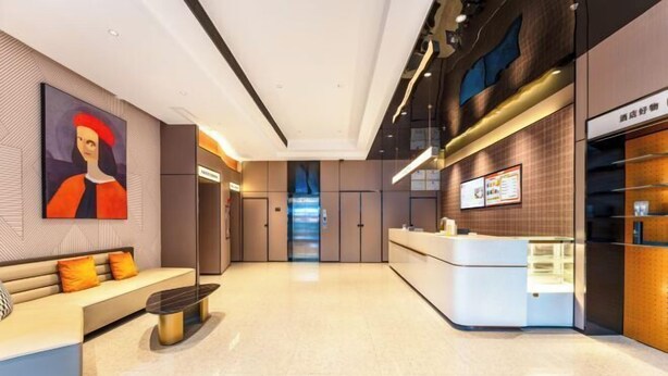 A modern hotel lobby with a reception desk, seating area, and a large painting on the wall. - Bohan Hotel (Guangzhou Olympic Sports Center – Tangxia Metro Station Branch) (Guangzhou)
