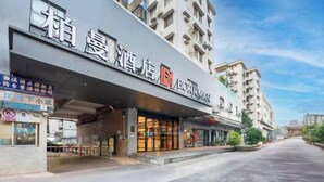 A hotel with a modern facade, large glass windows, and a prominent signage. - Bai Man Hotel (Guangzhou Financial City Tangxia Metro Station) (Guangzhou)