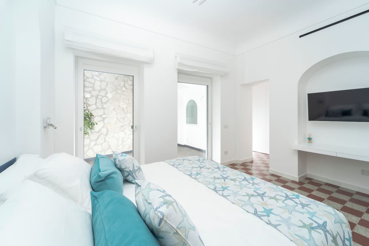 Une chambre à coucher avec un lit, une télévision et un mur en pierre.