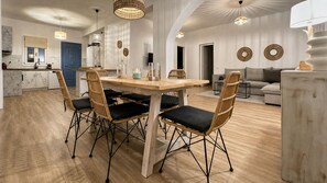 A modern kitchen with a dining area, featuring a wooden table and chairs, and a built-in oven.