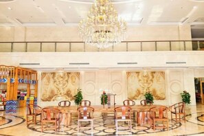 A spacious lobby with a chandelier, a reception desk, and a seating area with chairs. - BI SHUI LAN TIAN GRAND HOTEL (Napo)