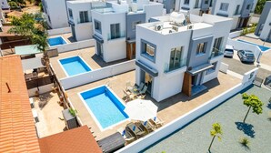 Ein modernes Wohngebäude mit Dachpool, mehreren Balkonen und freiem Blick auf die umliegende Nachbarschaft.