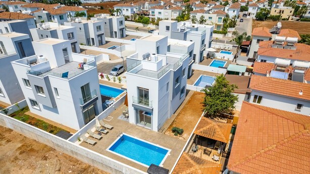 Ein moderner Wohnkomplex mit mehreren Gebäuden, Dachpools und einem zentralen Schwimmbecken.