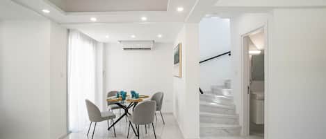 Un interior moderno con comedor, escalera y pasillo.