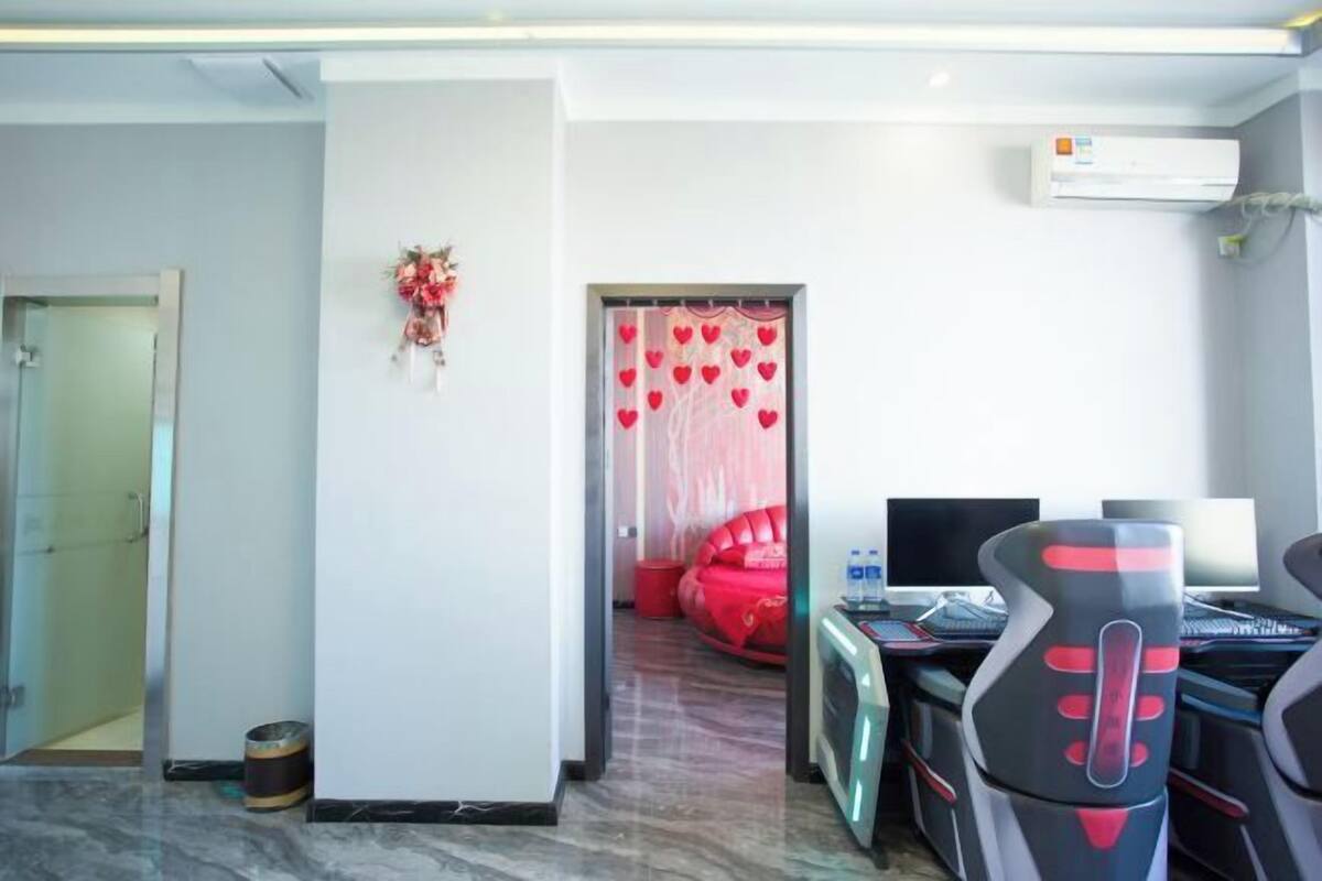 Een hotelkamer met een bed, een bureau met een computer en een stoel.