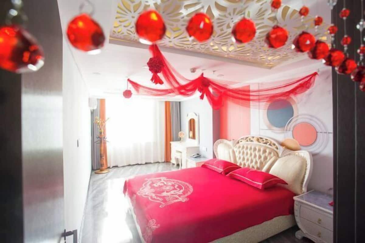A bedroom with a large bed, a desk, and a chair.