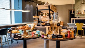 Un buffet de petit-déjeuner proposant une variété de viennoiseries, de pains et de boissons.