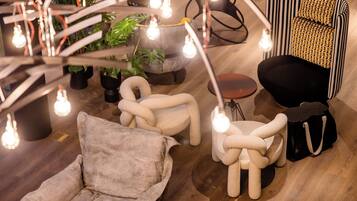 A modern lounge area with a sofa, armchair, ottoman, and a small table.