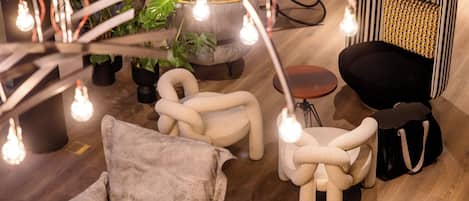 A modern lounge area with a sofa, armchair, ottoman, and a small table.
