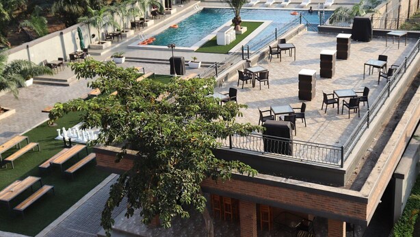 A rooftop pool area with lounge chairs, tables, and a small pool.