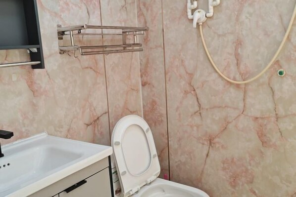 Ein Badezimmer mit Toilette, Waschbecken und Handtuchhalter.
