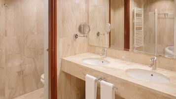 A bathroom with two sinks, a mirror, and a towel rack.