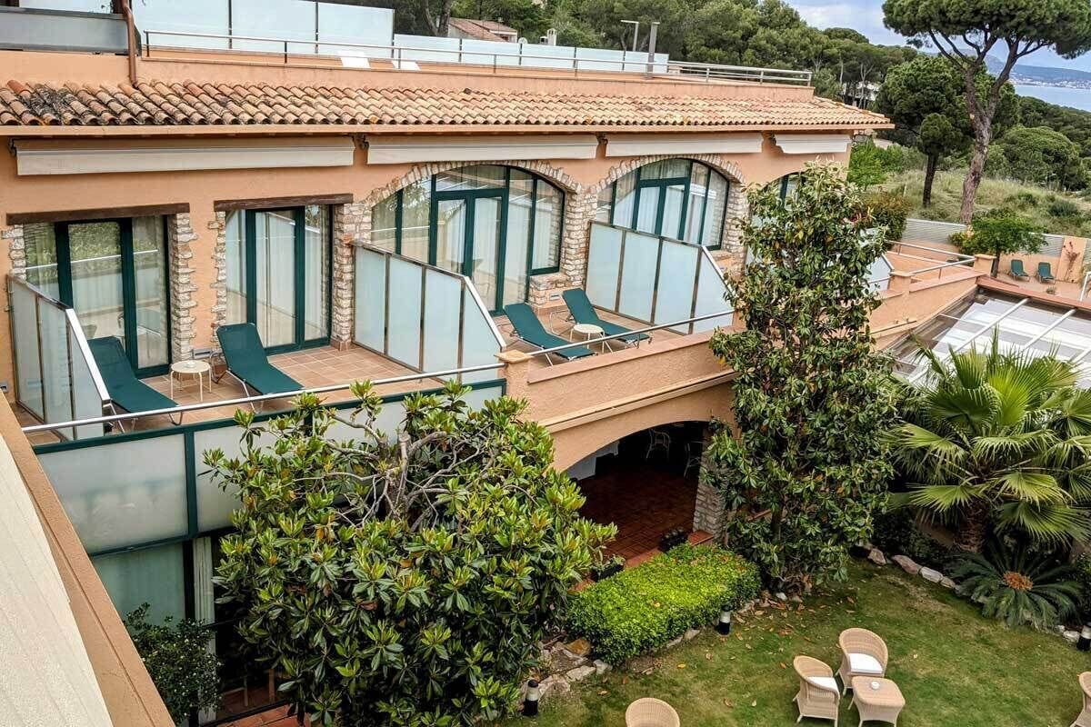 En villa i medelhavsstil med en terrass, utomhusmöbler och en frodig trädgård.