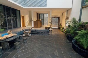 A spacious indoor area with a tiled floor, seating arrangements, and potted plants. - Guanhai Yayuan (Dali City)