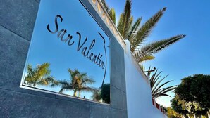 Un bâtiment avec une enseigne réfléchissante sur laquelle on peut lire « San Valentín ».