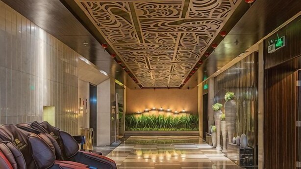 A hotel lobby with a patterned ceiling, a reception desk, and a wall with vertical plants. - Huasheng Hotel (Shanyin)
