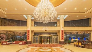 A lobby with a grand chandelier, a reception desk, and a patterned floor. - Huasheng Hotel (Shanyin)