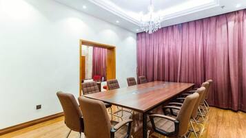 A conference room with a long table, chairs, and a chandelier.