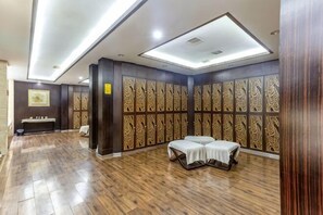 Una habitación con piso de madera, una banca, una mesa y paredes con diseño.
