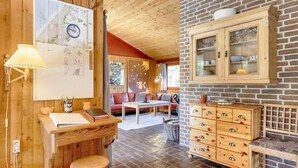 A cozy room with a wooden desk, a chair, a dining table, and a cabinet with drawers. - 6 Person Holiday Home in Blokhus (Blokhus)