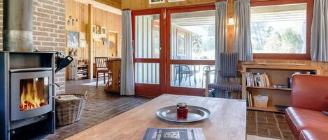 Una sala de estar acogedora con chimenea, muebles de madera y obras de arte en las paredes.