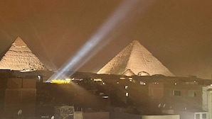 Yökuva pyramideista, joiden välissä näkyy valonsäde.