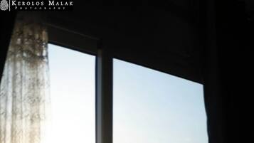 A window view of a mountain with a cityscape in the background.