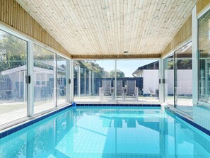 Swim and relax in a serene pool area with a clear view of the surrounding outdoor space.