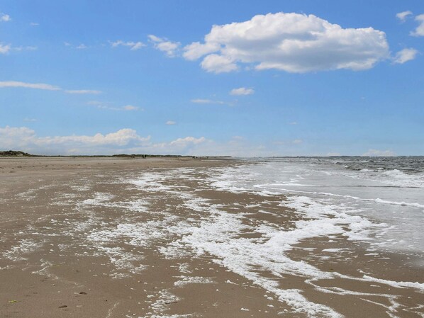 A beach with waves, a clear sky, and distant land. - 5 Star Holiday Home in Romo (Rømø)