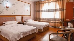 A hotel room with two beds, a large floral wall decoration, a window with curtains, a small table with a kettle, and a wicker chair. - Oyo Yongxing Hotel (Loudi)