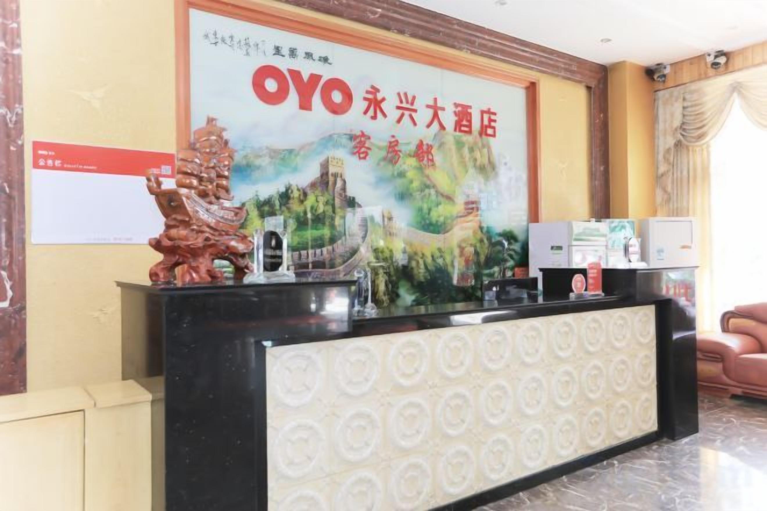 A hotel reception desk with a large sign, a decorative lion statue, and a modern design.