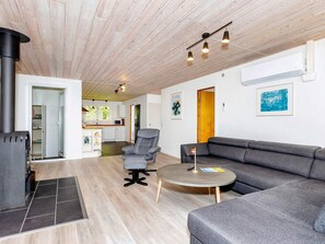 A modern living room with a sofa, armchair, and round coffee table. - 4 Star Holiday Home in Gedsted (Gedsted)
