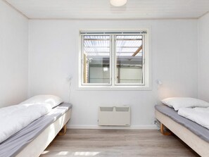 A room with two beds, a window, and a wall-mounted heater. - 4 Star Holiday Home in Gedsted (Gedsted)