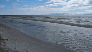 A beach with a wide sandy shore and gentle waves.