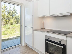 A modern kitchen with a built-in oven, a stovetop, and a refrigerator.