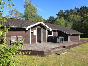 A two-story building with a covered patio area, a door, and a window. - 4 Star Holiday Home in Hadsund (Hadsund)