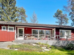 A red building with a balcony, large windows, and a tiled roof. - 6 Person Holiday Home in Djurhamn (Fågelbrolandet)