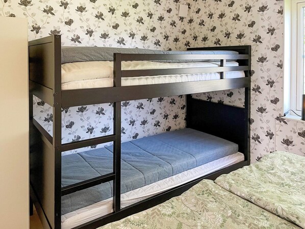 A bunk bed with a floral wallpaper pattern, a window with a view, and a small bedside table. - 4 Star Holiday Home in Solvesborg (Sölvesborg)