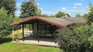 A house with a covered patio, a dining area, and a large window. - 7 Person Holiday Home in Karrebaeksminde (Karrebæksminde)