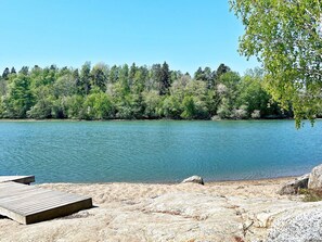 A lakeside view with a wooden dock and a rocky shoreline. - 4 Star Holiday Home in Stora Vika (Stora Vika)