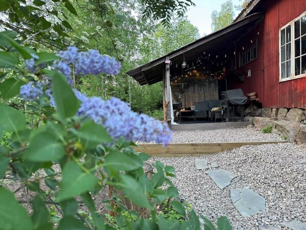 A rustic cabin with a gravel pathway leading to a covered outdoor seating area. - 3 Person Holiday Home in Munkforss (Munkfors)