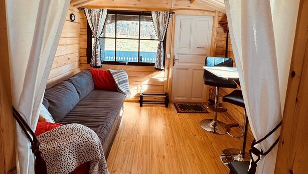 A cozy cabin interior with a wooden ceiling, a sofa, a dining table, and a kitchen area. - 3 Person Holiday Home in Munkforss (Munkfors)