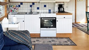 A compact kitchen with white cabinets, a built-in oven, and a coffee maker. - 6 Person Holiday Home in Laholm (Skummesloevsstrand)