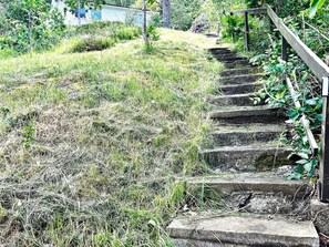 A set of stone steps leading up a grassy slope with a wooden handrail on the right. - 4 Star Holiday Home in Uddevalla (Uddevalla)